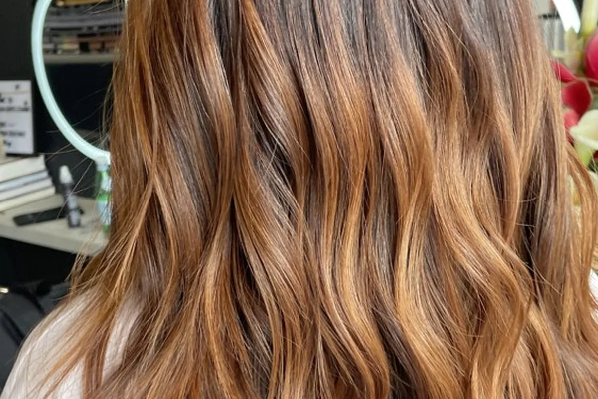 Brunette roots blending into lighter balayage lengths