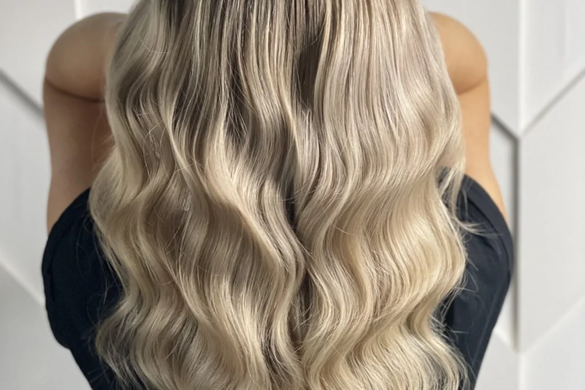 Multi-tonal blonde hair with darker roots and soft waves