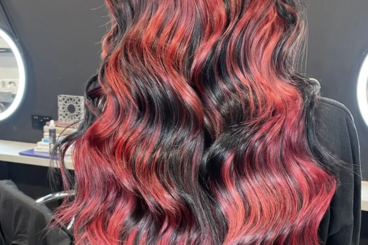 Vivid red colour through dark wavy hair