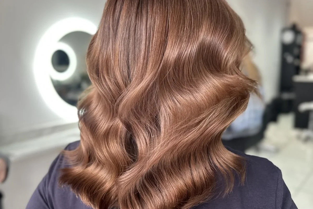 Glossy warm brunette hair styled in soft waves