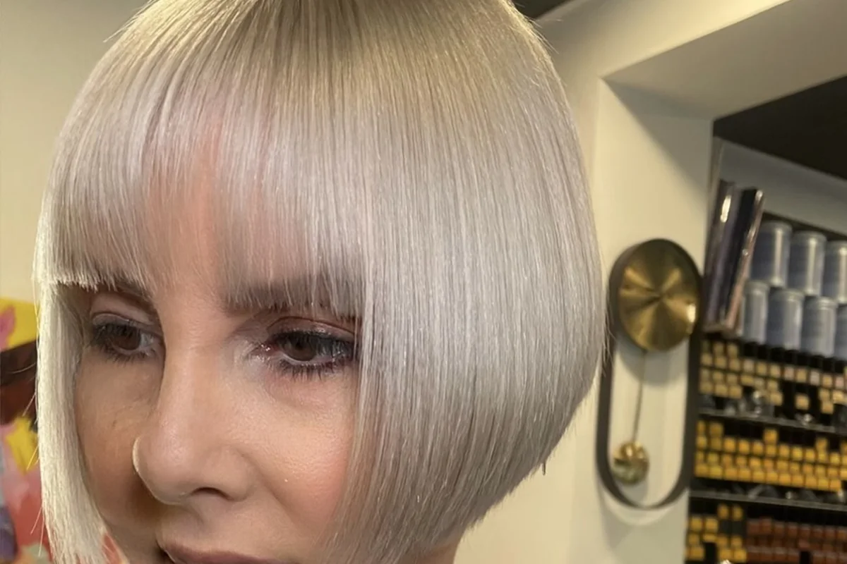A precise platinum blonde bob with a full fringe