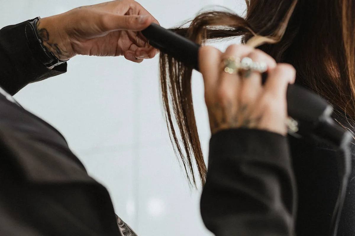 A stylist shaping waves with a heated styling tool