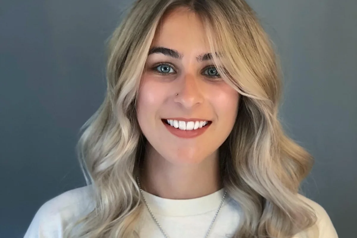 Blonde hair with a soft root and face-framing waves